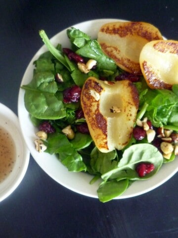 a beautiful summer salad with grilled pears and chicken, lettuce, dried cranberries, and feta cheese with a pear vinegarette.