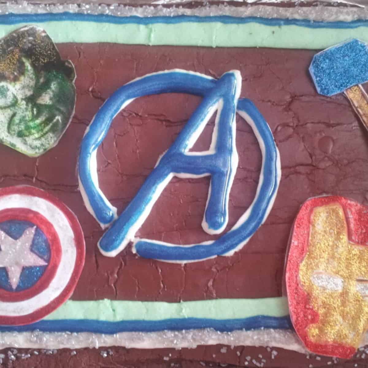 easy avengers cake with avengers logo, captain america, hulk, thor and iron man cake topper