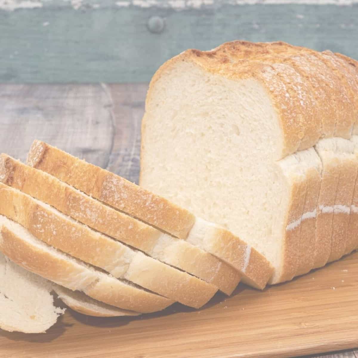 A close-up photo of a loaf of easy white bread. The bread is golden brown on the outside and has a soft and fluffy texture on the inside