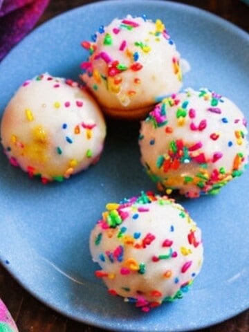 beautiful baked funfetti donut holes topped with jimmy sprinkles and glaze