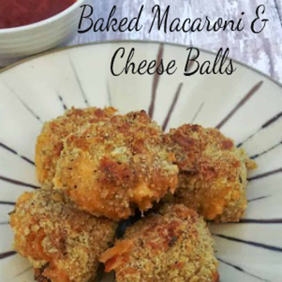  A plate of baked macaroni and cheese balls with a side of marinara sauce for dipping. The macaroni and cheese balls are golden brown and crispy on the outside, and cheesy and gooey on the inside. The marinara sauce is red and chunky.