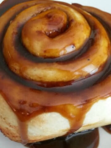 homemade caramel sauce made with coconut sugar drizzled on a cinnamon roll
