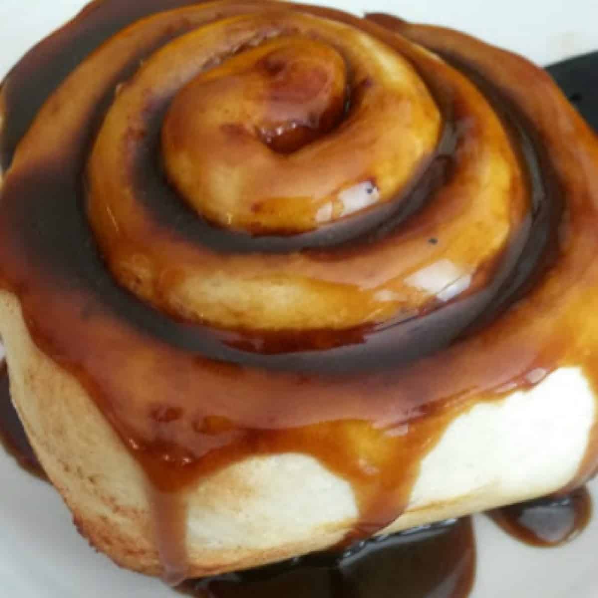 homemade caramel sauce made with coconut sugar drizzled on a cinnamon roll