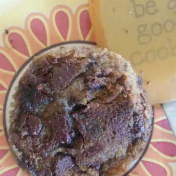 Image of a pan of stovetop chocolate chip cookies. The cookies are golden brown and have a slightly crispy exterior. They are topped with melted chocolate chips