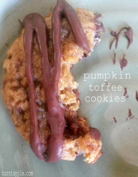 Delicious homemade pumpkin toffee cookies with a soft, chewy texture. These golden-brown treats are studded with sweet toffee bits and have a warm, spiced aroma. The cookies are perfectly shaped, showcasing their crackly tops and enticing caramel-colored edges