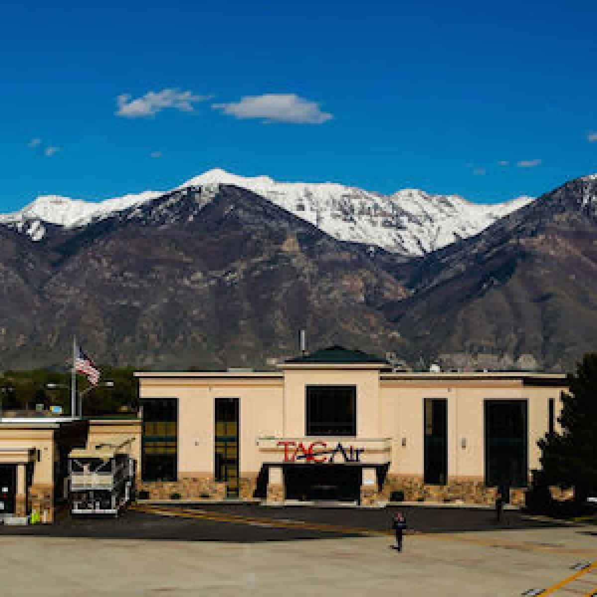 this picture shows the provo airport review with the rocky mountains in the background of the tan colored airport