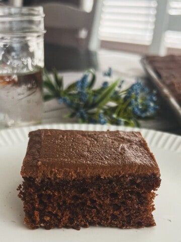 fA rectangular chocolate cake with a chocolate frosting on a baking sheet. this recipe is a traditional texas sheet cake recipe.