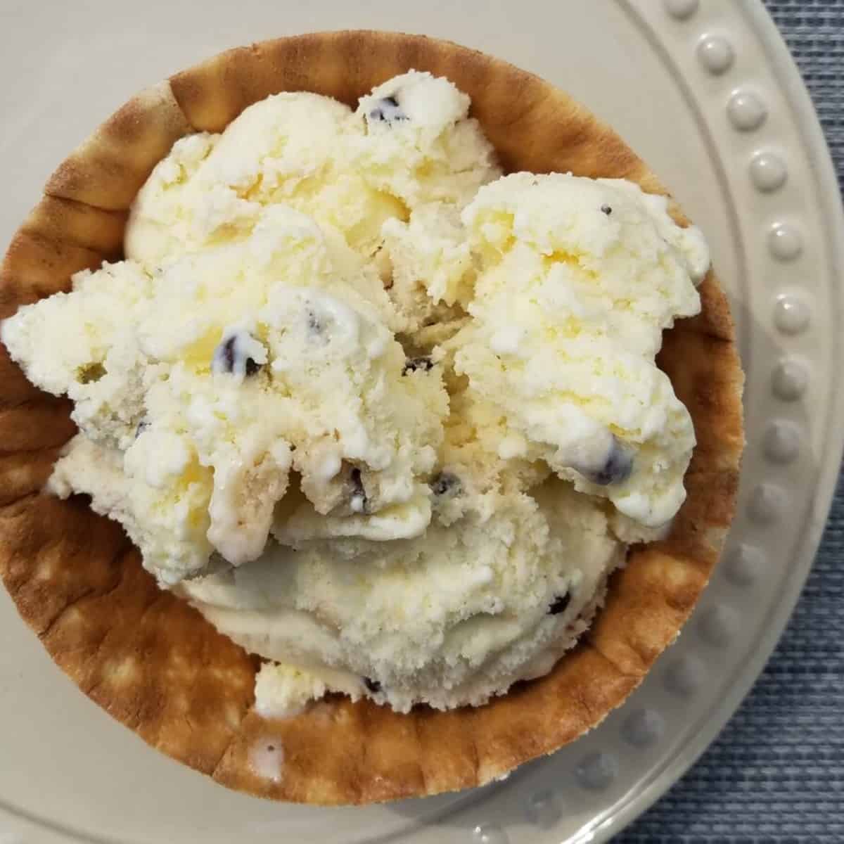 A heaping bowl of homemade cookie dough ice cream recipe, packed with chunks of chocolate chip cookie dough and swirls of rich cookie dough batter.