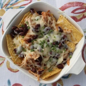 A tempting platter of BBQ chicken nachos recipe piled high with melty cheese, beans, corn, and fresh cilantro