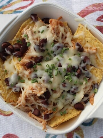 A tempting platter of BBQ chicken nachos recipe piled high with melty cheese, beans, corn, and fresh cilantro