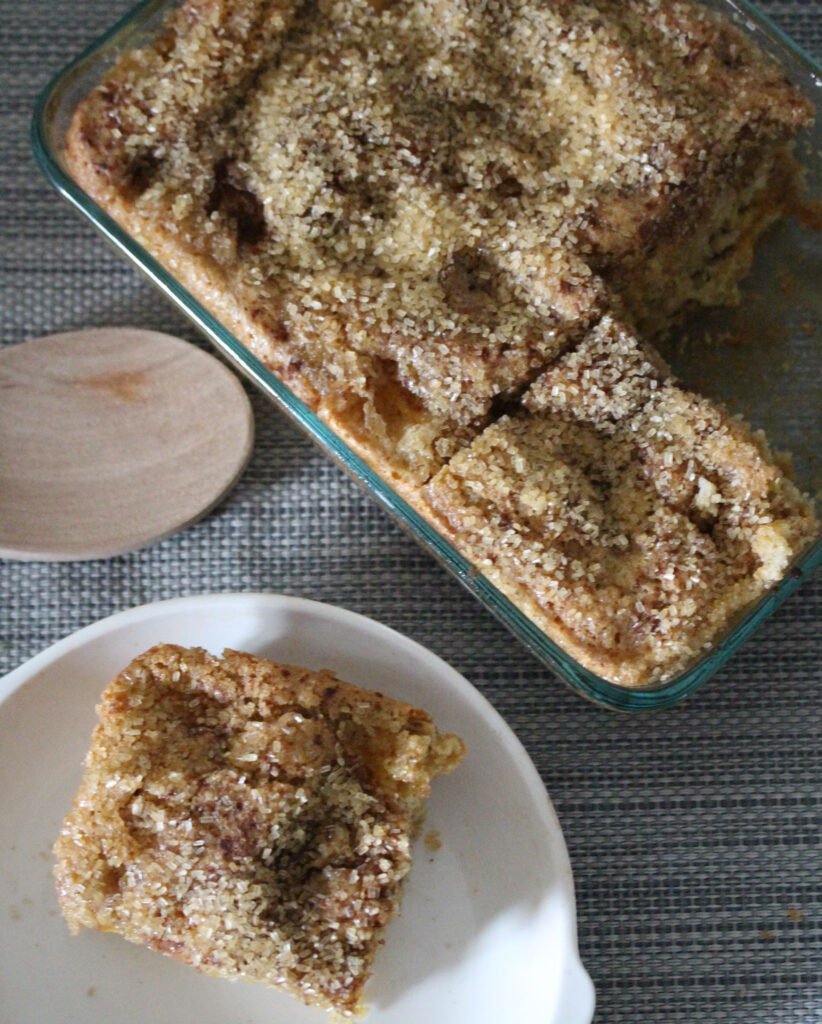 A batch of freshly baked snickerdoodle bars, featuring a soft and chewy texture. The bars are golden-brown with a crackly cinnamon sugar crust on top. They are cut into square servings and arranged on a plate, ready to be enjoyed as a delicious treat