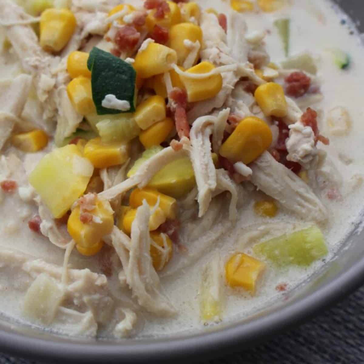 A steaming bowl of Panera Bread Summer Corn Chowder, ready to be enjoyed with a side of crusty bread