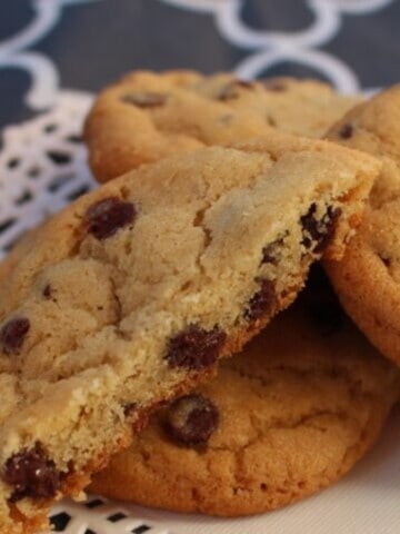 A close-up photo of golden brown twice baked cookies, revealing a crinkled, crackly surface studded with melty dark chocolate chips