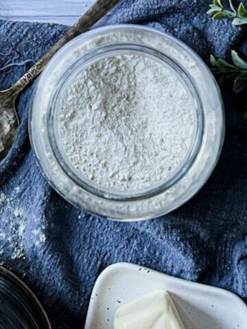 A close-up photo of a recipe for gluten-free self-rising flour displayed on a smartphone screen. The title, "Gluten-Free Self-Rising Flour", is displayed in a large, bold font at the top of the screen. Below the title, the ingredient list is visible, with each ingredient clearly listed and its quantity written beside it. Step-by-step instructions appear below the ingredients, with small images illustrating each step.