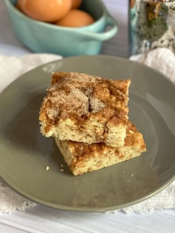 Snickerdoodle sheet pan breakfast is a bar-shaped cake with a crumbly coffee cake-like texture. It is flavored with cinnamon and sugar throughout and has a cinnamon sugar streusel topping