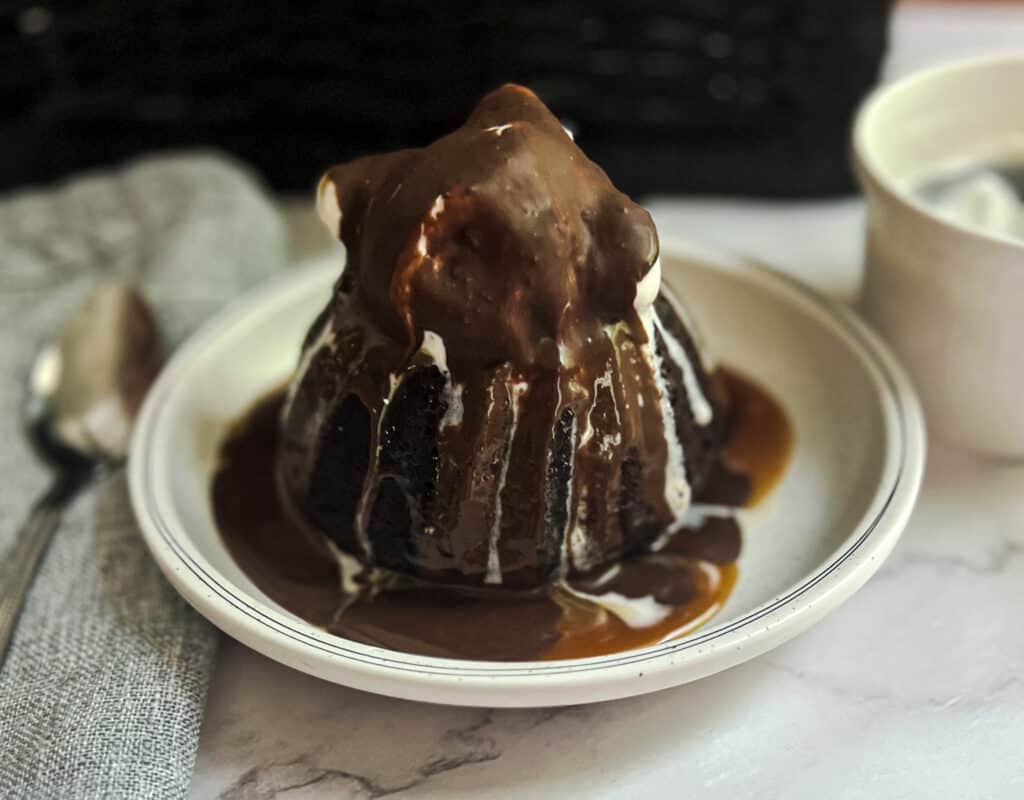 A slice of irresistible Chili's Molten Lava Cake with a gooey chocolate center, served with a scoop of vanilla ice cream and drizzled with chocolate sauce