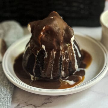 A slice of irresistible Chili's Molten Lava Cake with a gooey chocolate center, served with a scoop of vanilla ice cream and drizzled with chocolate sauce