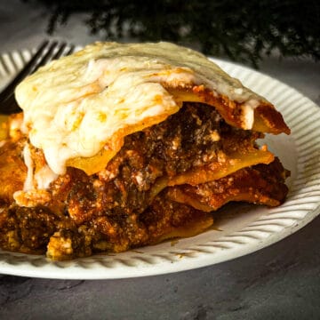 Image of a five ingredient gluten free lasagna dish. The lasagna is made with layers of pasta, tomato sauce, ricotta cheese, mozzarella cheese, and Parmesan cheese. The dish is baked in a oven until golden brown and bubbly.