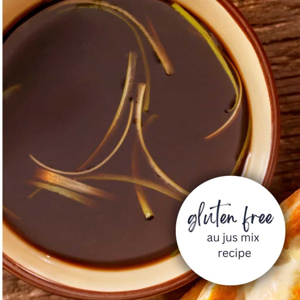 The image shows a bowl of gluten free au jus mix. The mix is a light brown color and has a slightly grainy texture. The au jus is simmering in a saucepan and has a rich, brown color. There is a piece of bread on a plate next to the saucepan.