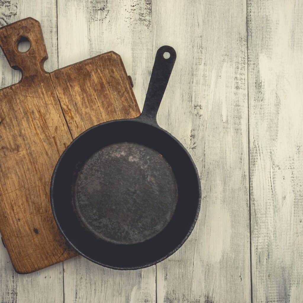 a picture of a black cast iron pan and a cutting board. the description includes tips for organizing your cookware when you have food allergies. 