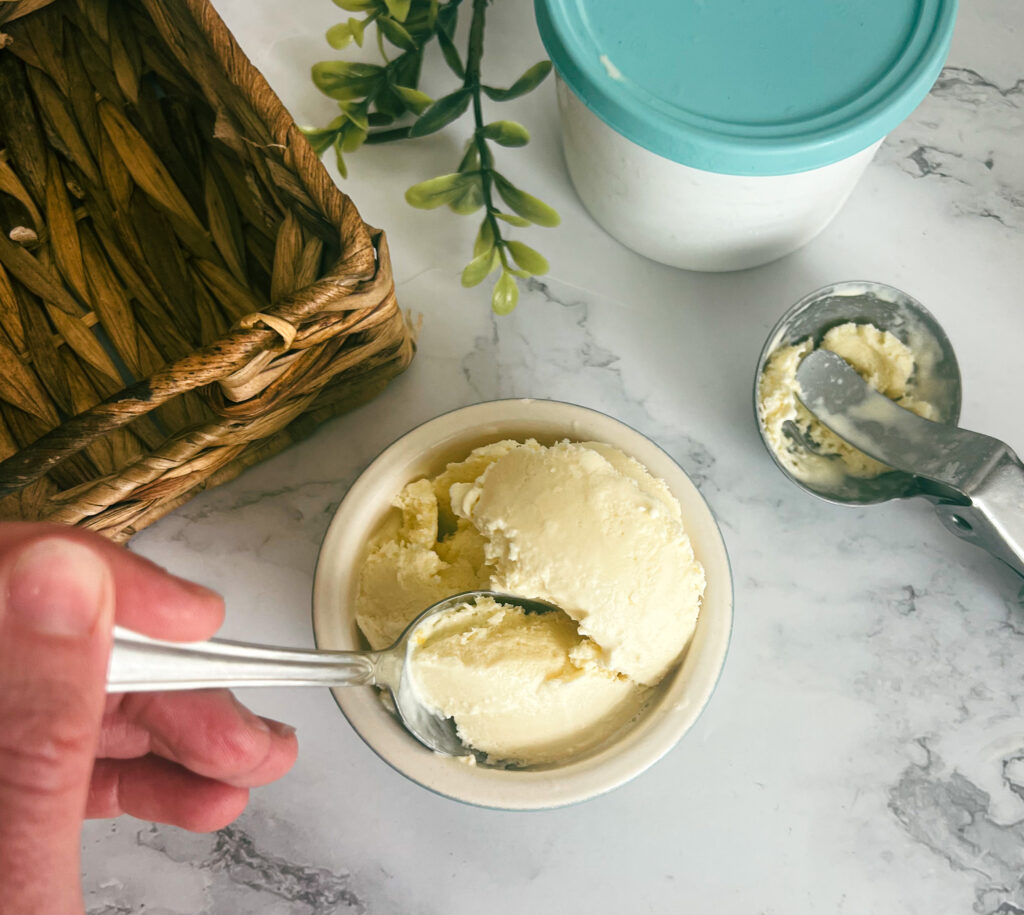 A copycat Häagen-Dazs vanilla ice cream recipe. a person is scooping ice cream out of a bowl. 