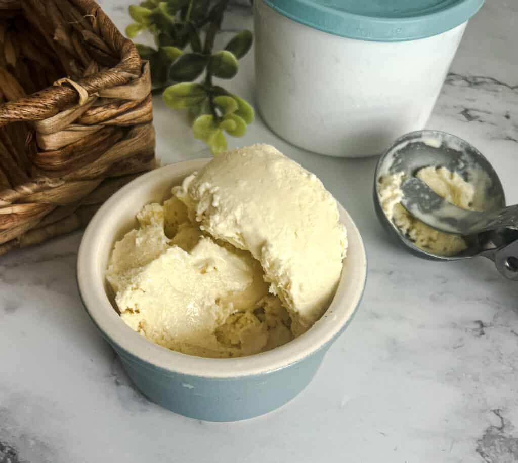 Image of a bowl of homemade vanilla ice cream inspired by the famous Haagen-Dazs flavor. The ice cream is rich and creamy, with a velvety texture. It's perfectly scooped into a bowl. Copycat Haagen Daz vanilla ice cream recipe