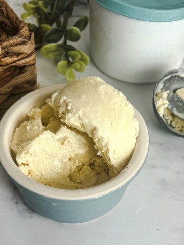 Image of a bowl of homemade vanilla ice cream inspired by the famous Haagen-Dazs flavor. The ice cream is rich and creamy, with a velvety texture. It's perfectly scooped into a bowl. Copycat Haagen Daz vanilla ice cream recipe