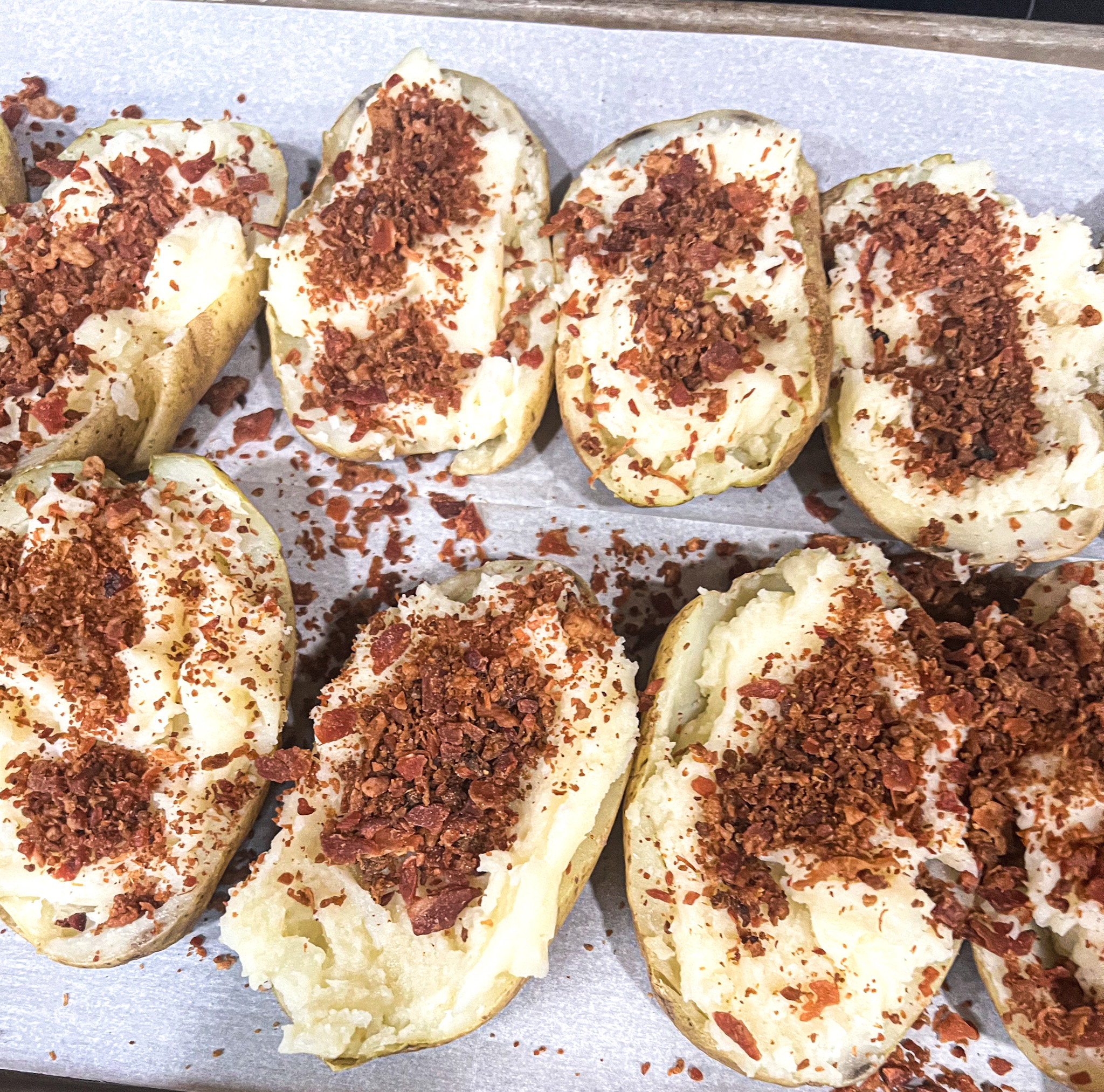bacon being added on twice baked potatoes