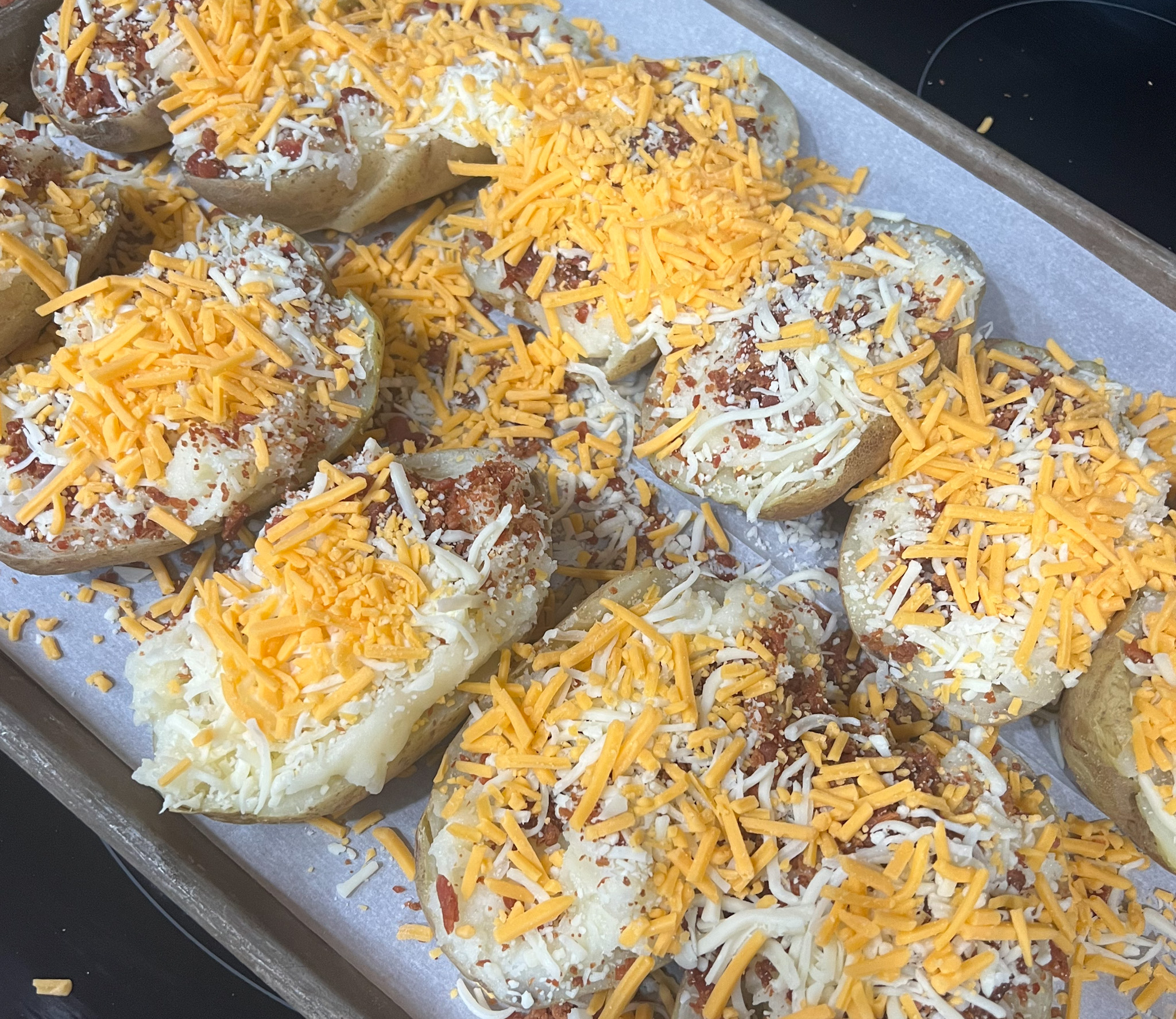 cheddar cheese sprinkled on top of twice baked potatoes