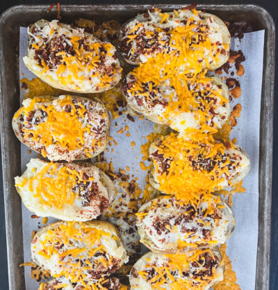 twice baked potatoes fresh out of the oven with melted cheese and bacon