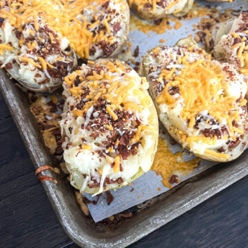 a picture of a twice baked potato with melted cheddar cheese and crispy bacon on top.
