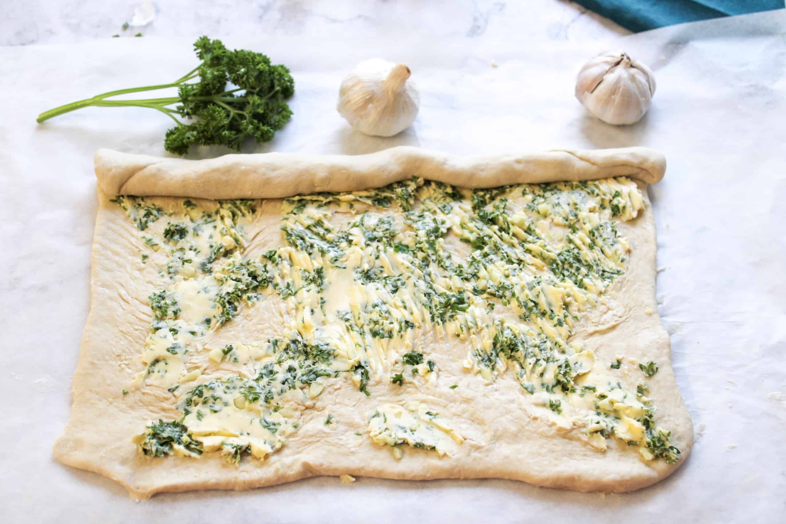 Prepare butter and herb mixture, then brush onto the garlic bread dough