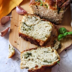 A golden brown garlic bread loaf, split open to reveal its soft, garlicky interior