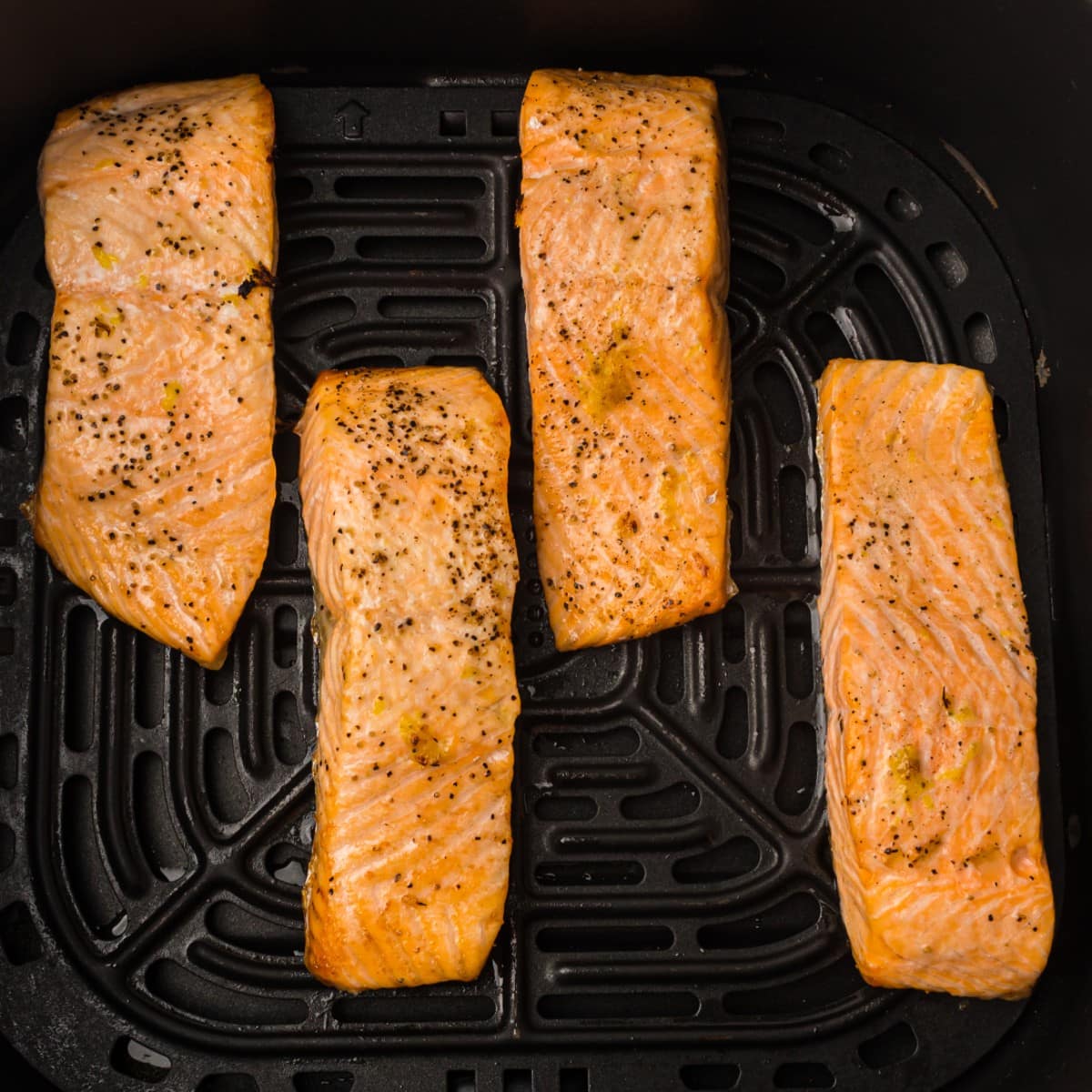 cook salmon fillets in the air fryer then sprinkle with parsley and garnish with a lemon wedge
