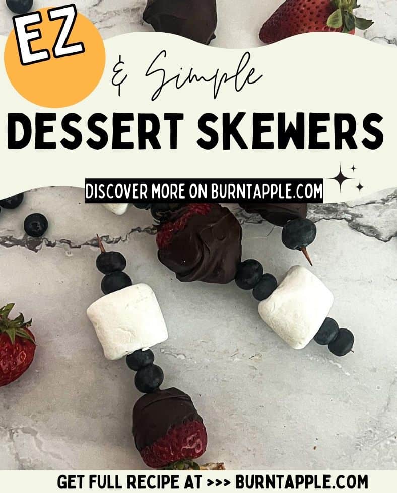 A colorful dessert skewer with fresh strawberries, blueberries, and marshmallows. The text "EZ & Simple DESSERT SKEWERS. Discover more on BurntApple.com. Get Full Recipe at BurntApple.com" is displayed in the background.