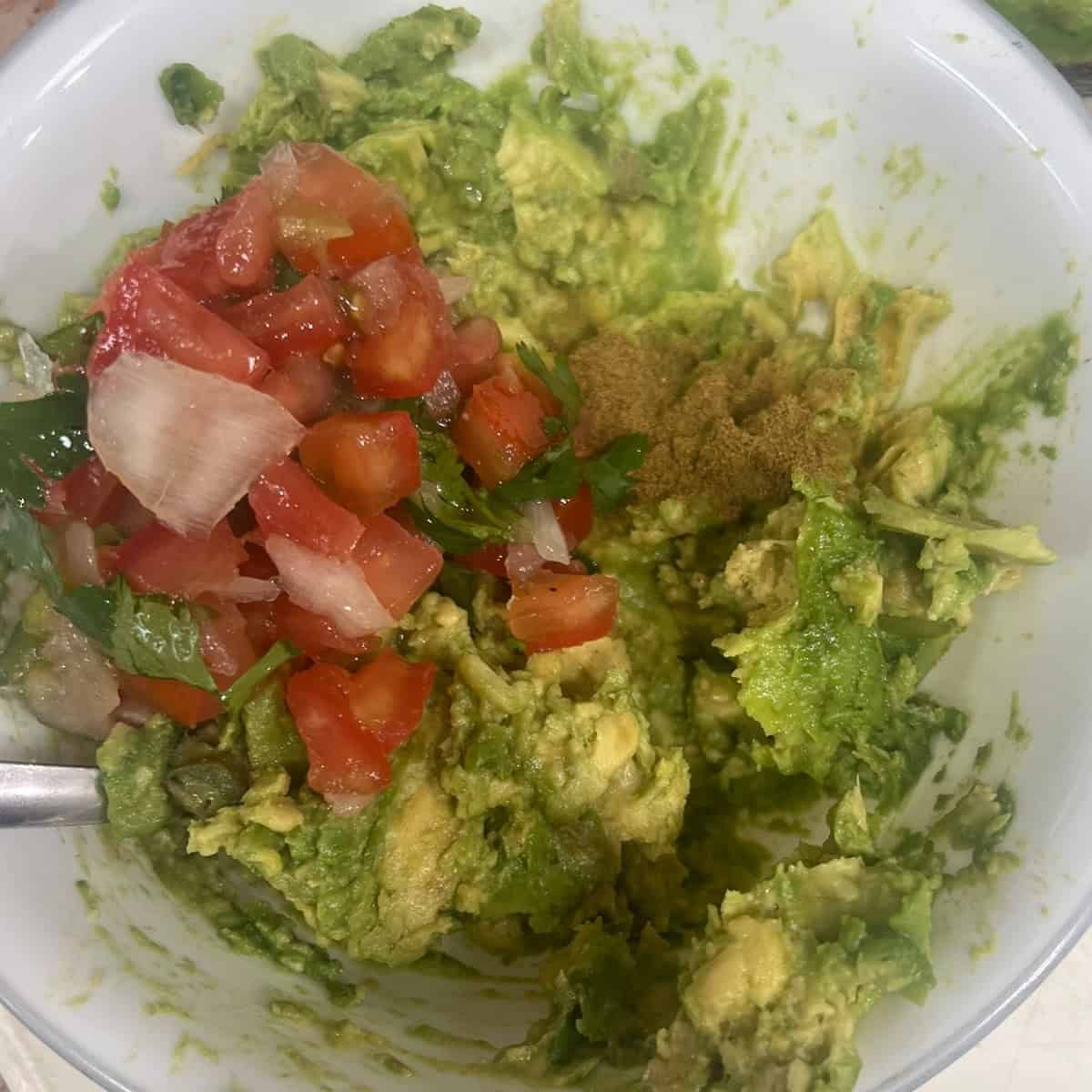 add salsa and cumin to your guacamole. Add salt and pepper if desired. 
