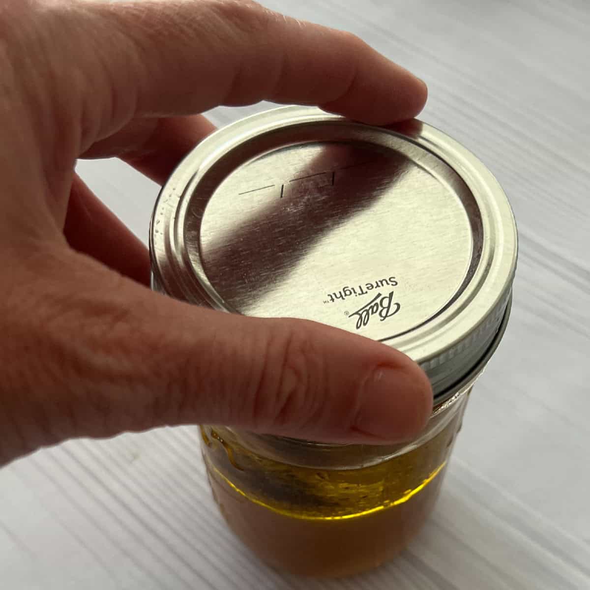 seal mason jar with apple cider vinaigrette inside